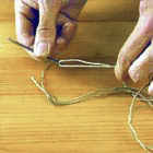 Trä en nål med garn och förbind med en knop