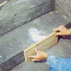 Använder en bräda som form för lagningen på trappan