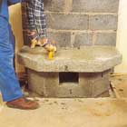 Lägg bruk på sockelns kanter och sätt nästa betongelement på plats