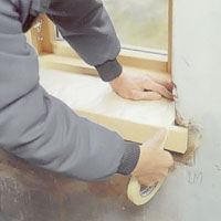 Skydda fönsterbänken med plastfolie och tejpa noga.