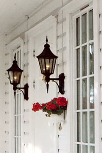 Utomhusbelysning med traditionella vägglyktor på varje sida om ytterdörren.
