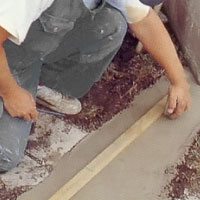 Mät ut och stick ner spikbeslagen i den våta betongen.