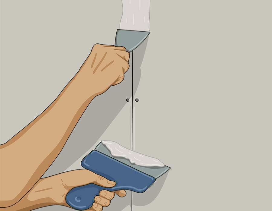 Hand som håller i en spackelspade och applicerar spackel som täcker över skarvar och skruvhål på en gipsvägg

