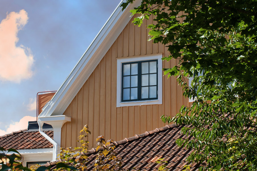 Bilden visar ett hus en molnig dag utan regn och blåst. Dessa dagar är idealiska för att måla på trä utomhus